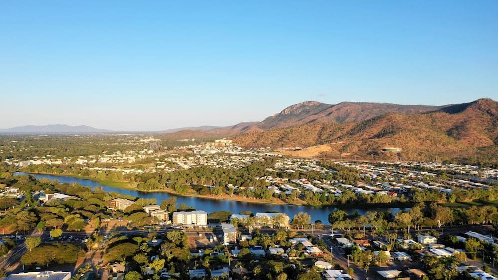 An Aerial View of a City Surrounded by Mountains and a River — Mareeba Golden Dried Mangoes in Townsville, QLD