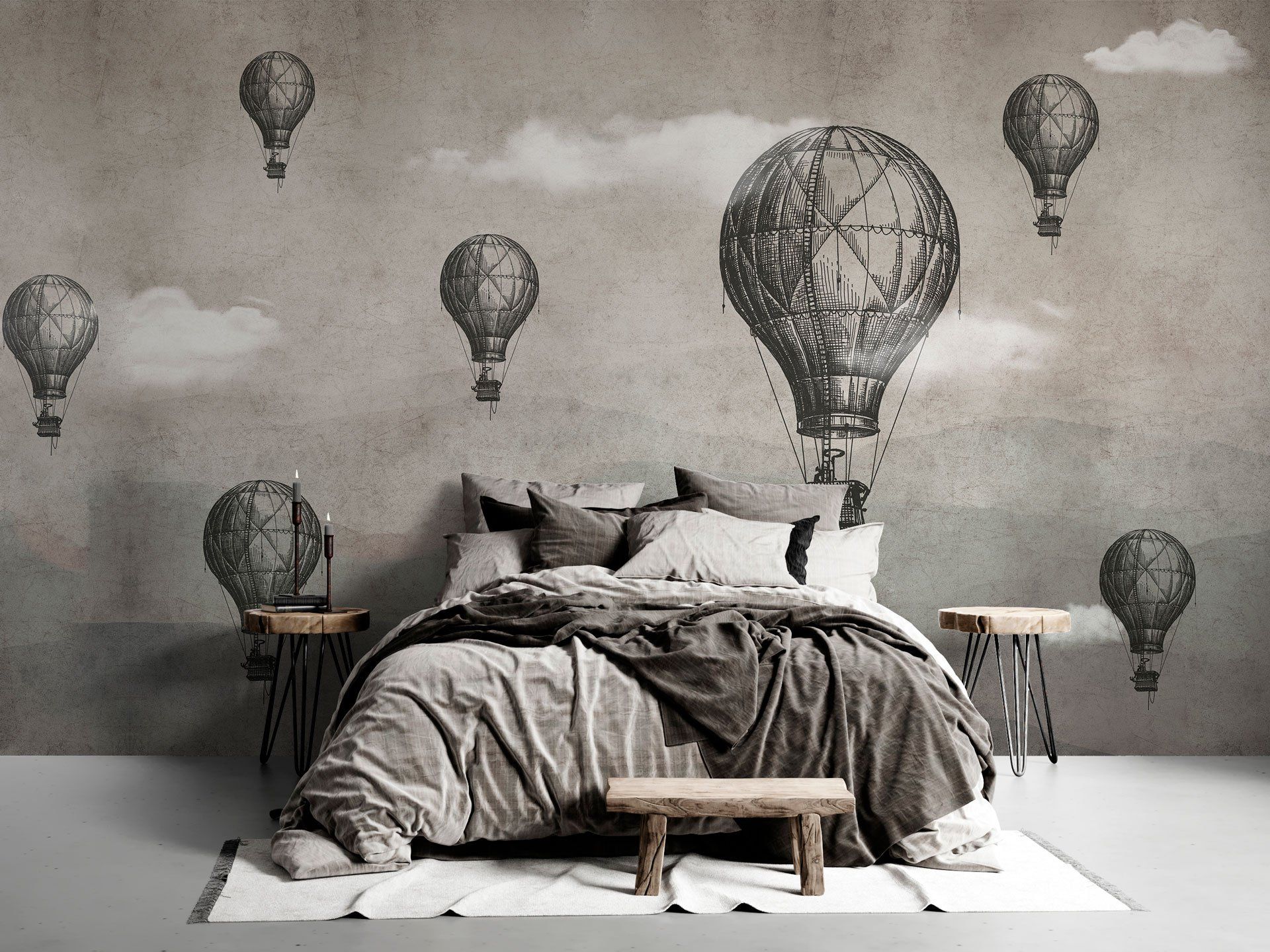 Una camera da letto con un letto e una parete decorata con mongolfiere.