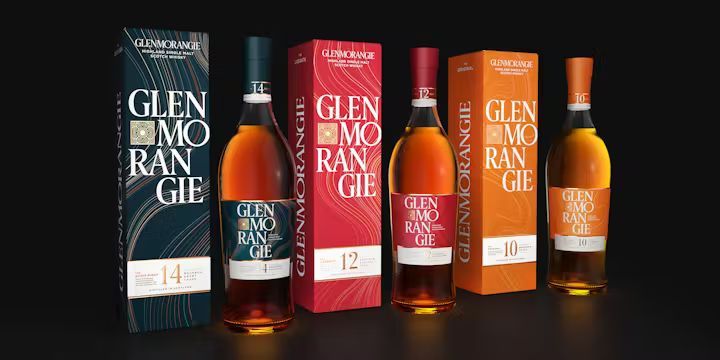 A row of glenmorangie bottles and boxes on a black background