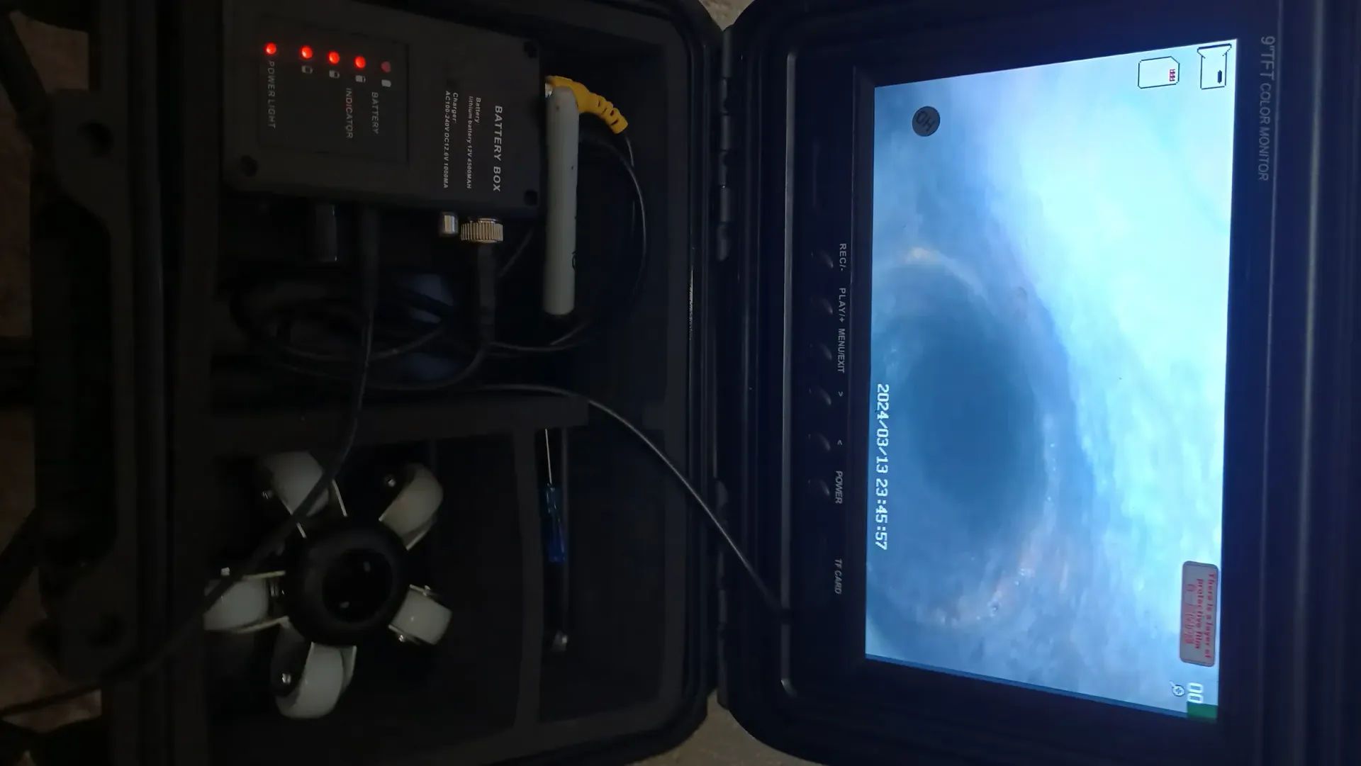 Inside a dark machine compartment, a blue-lit window shows a swirling underwater scene outside.