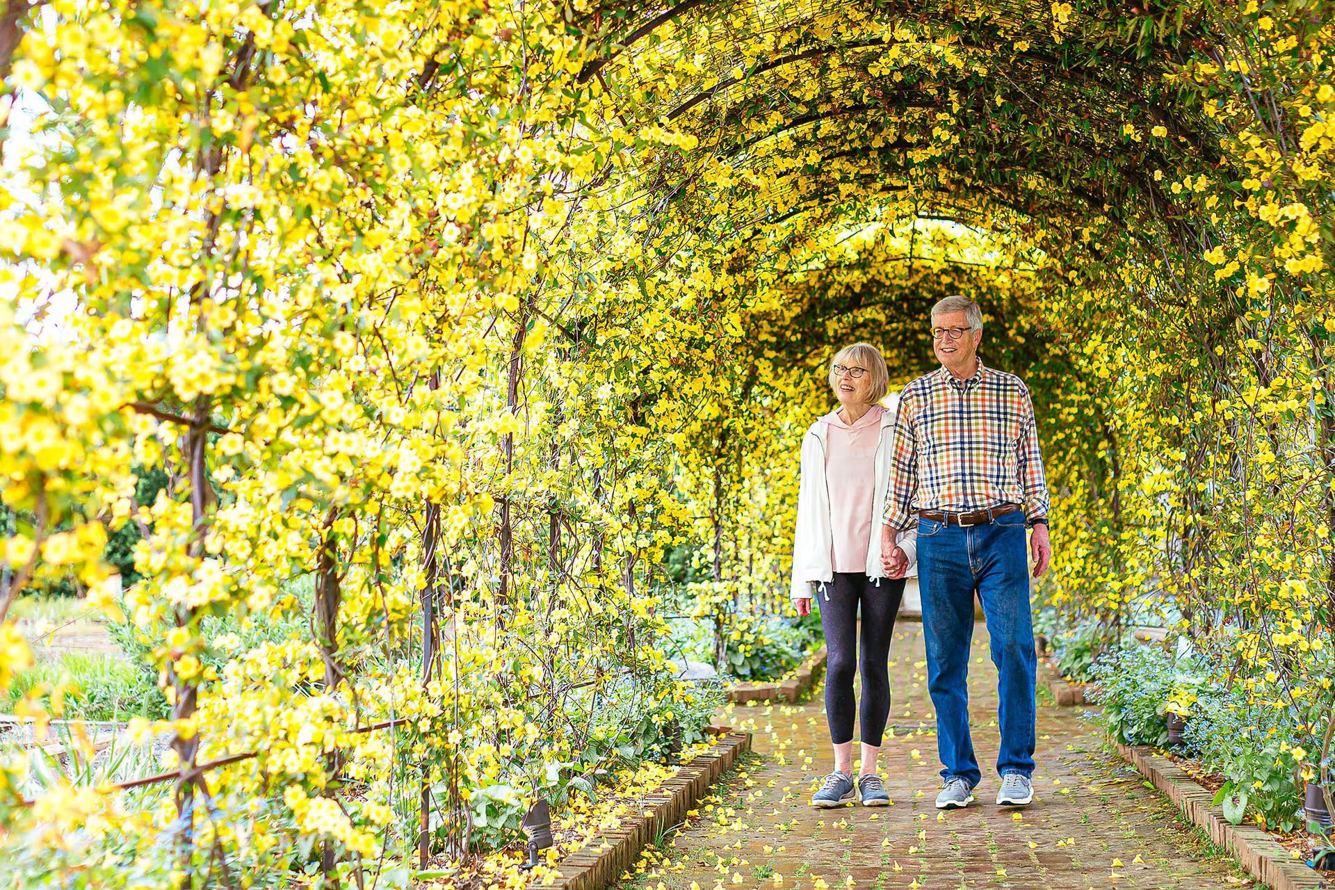 A man and a woman are walking under a yellow archway.