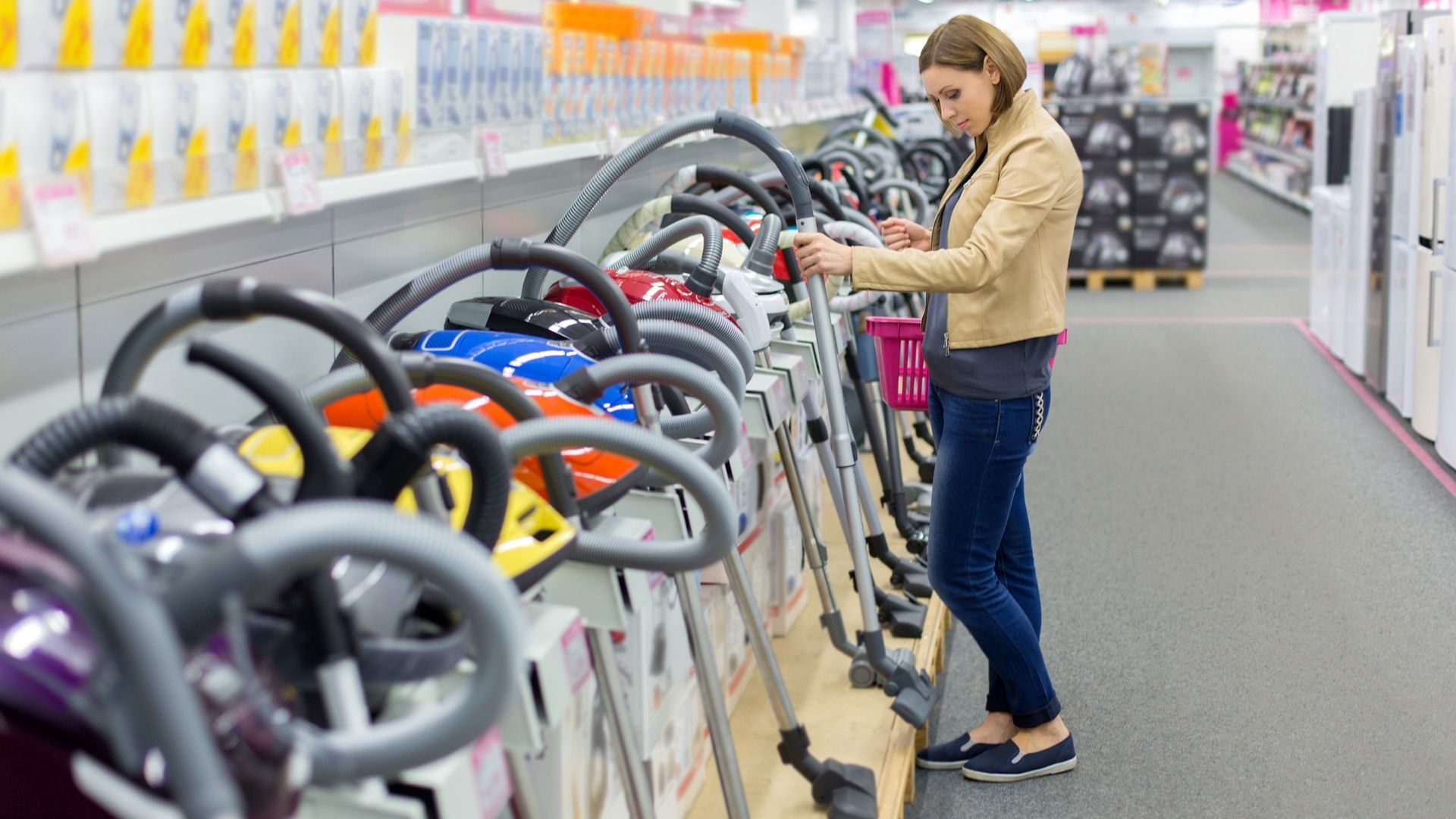 Woman shopping for a stroller in a baby store aisle