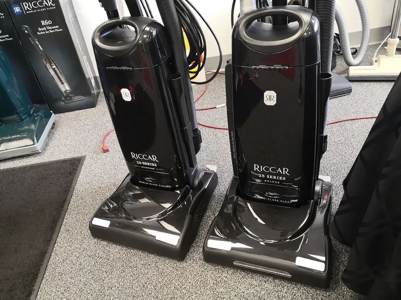Orange floor-cleaning machine being used indoors beside a person’s legs