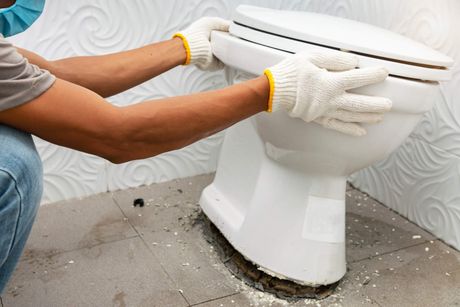 Plumber installing a toilet