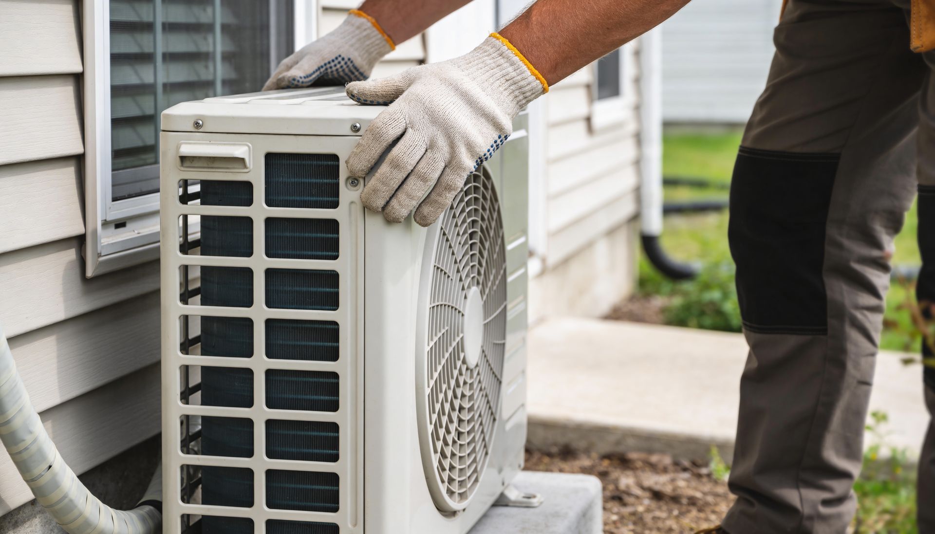HVAC contractor installing an exterior air conditioning unit during a residential HVAC installation service.
