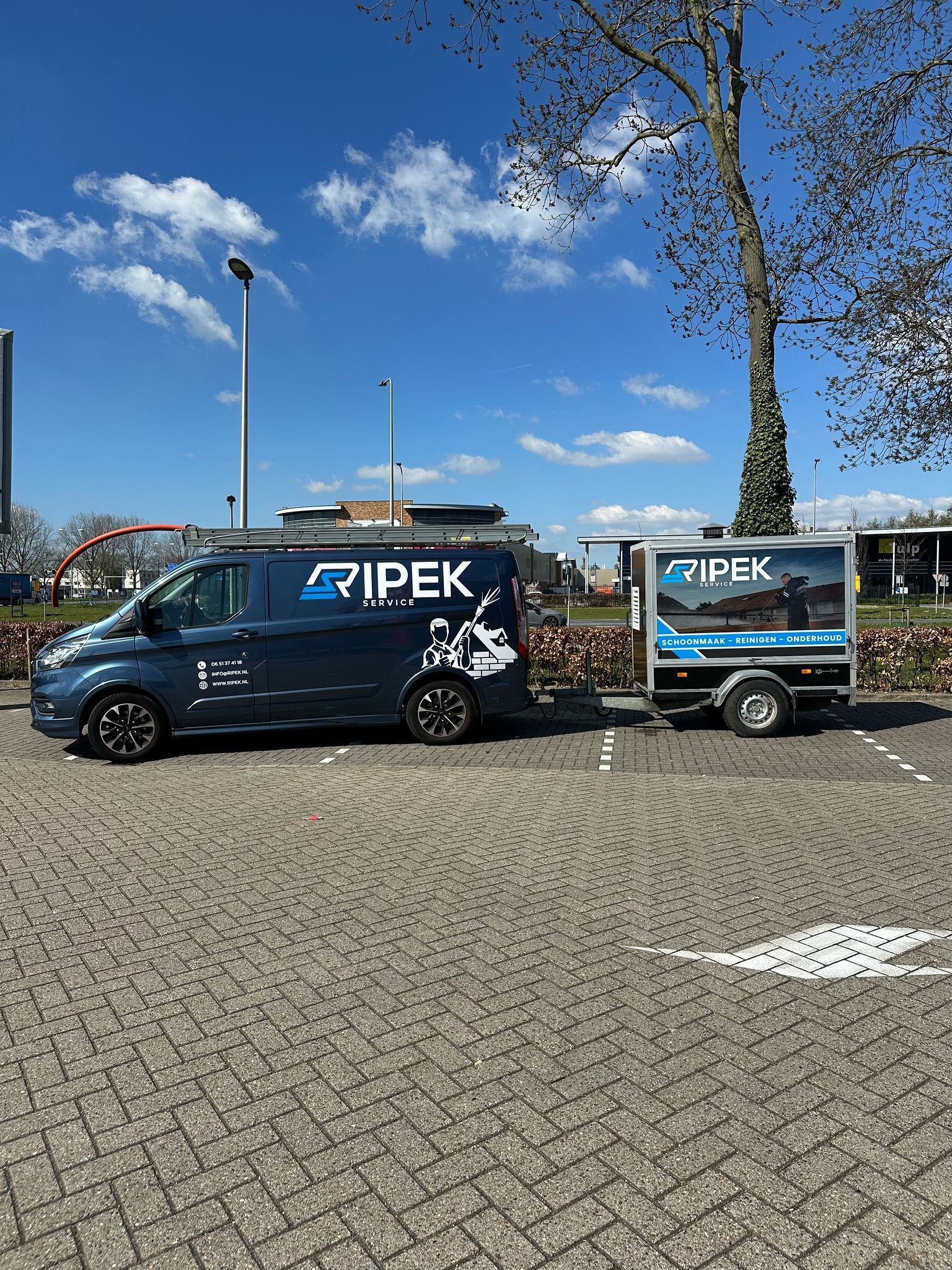 Donkerblauwe bestelwagen met aanhanger en 