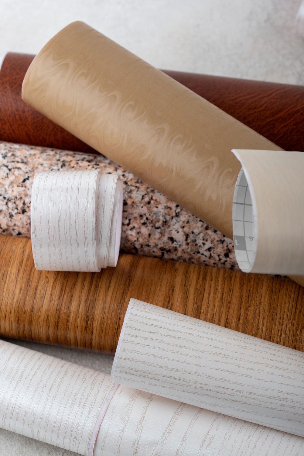 A bunch of different types of wallpaper are stacked on top of each other on a table.