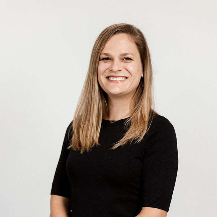 A woman in a black shirt is smiling for the camera