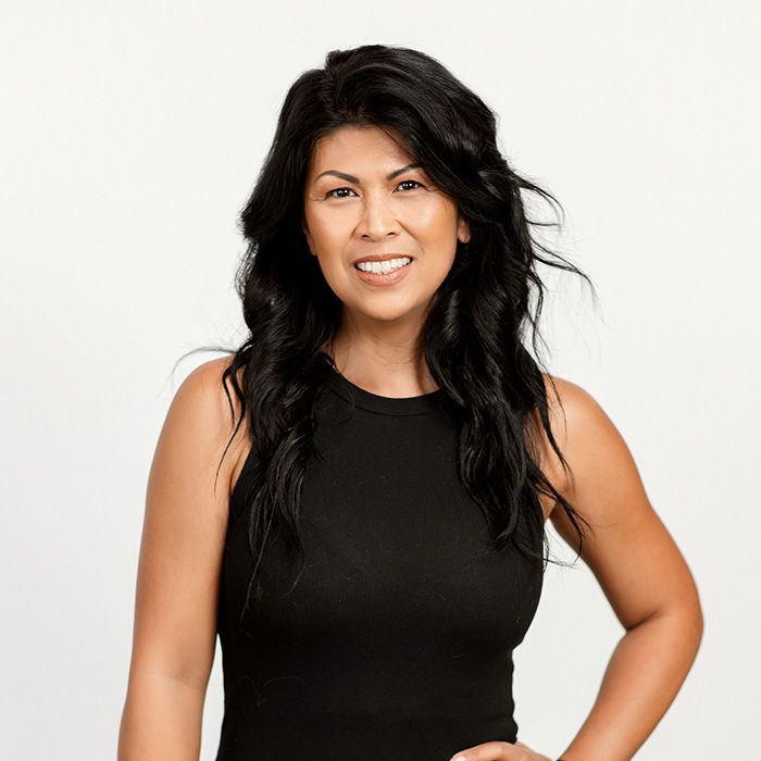 A woman in a black tank top is smiling for the camera