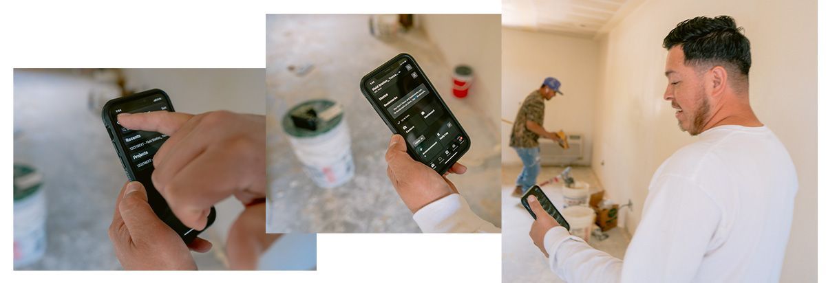 A man is holding a cell phone in his hand in a room.