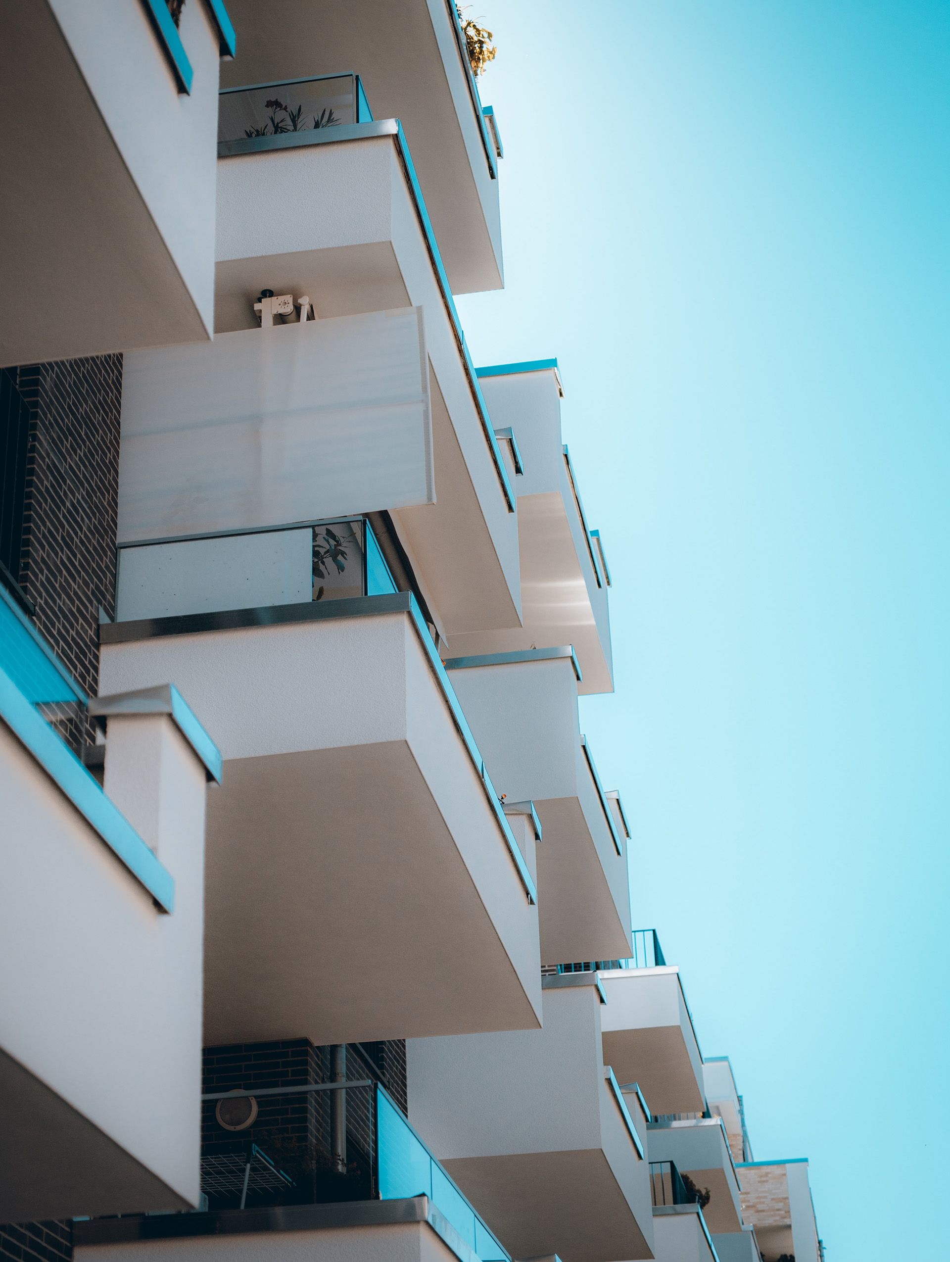 A building with many balconies and a blue sky in the background