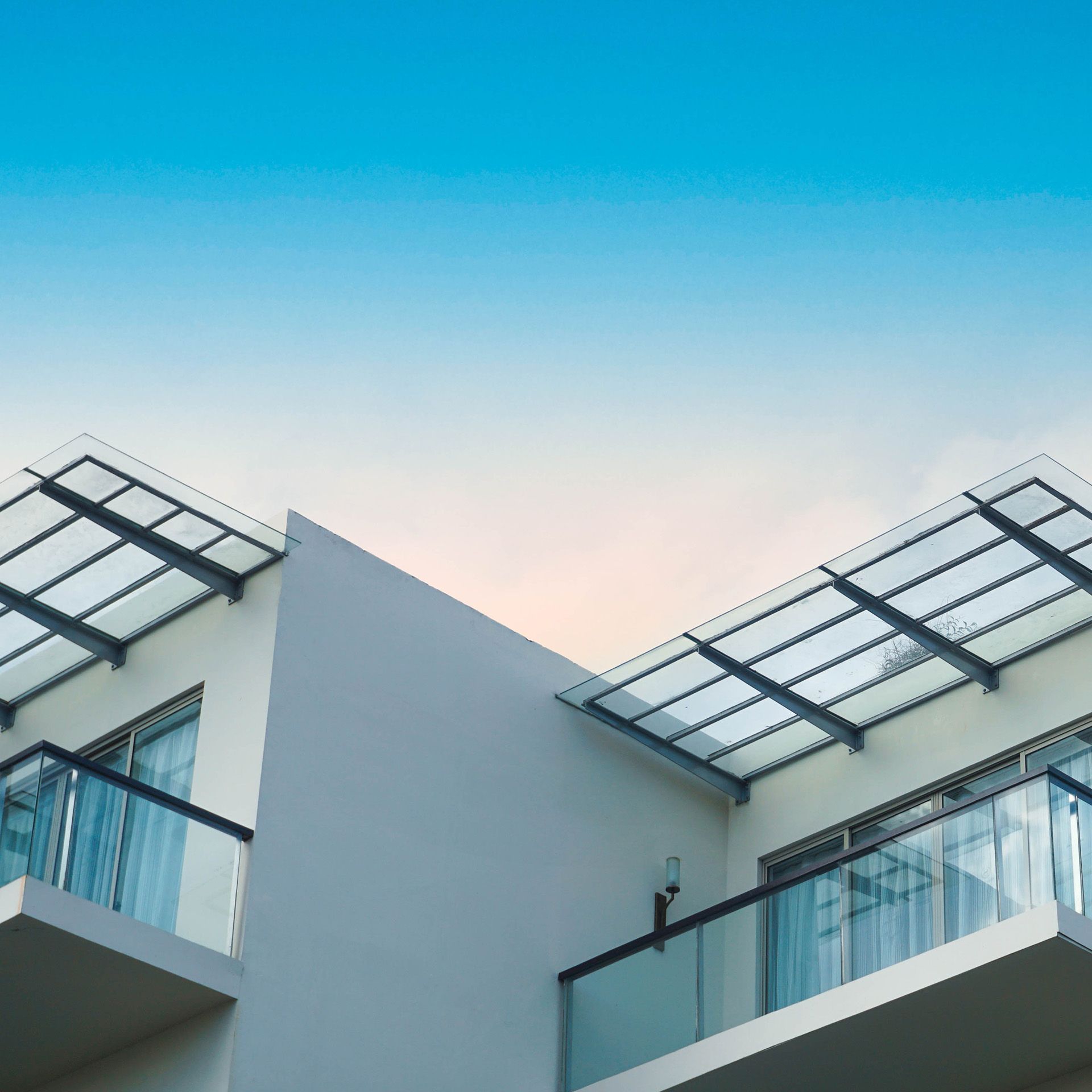 A building with a balcony and a blue sky in the background