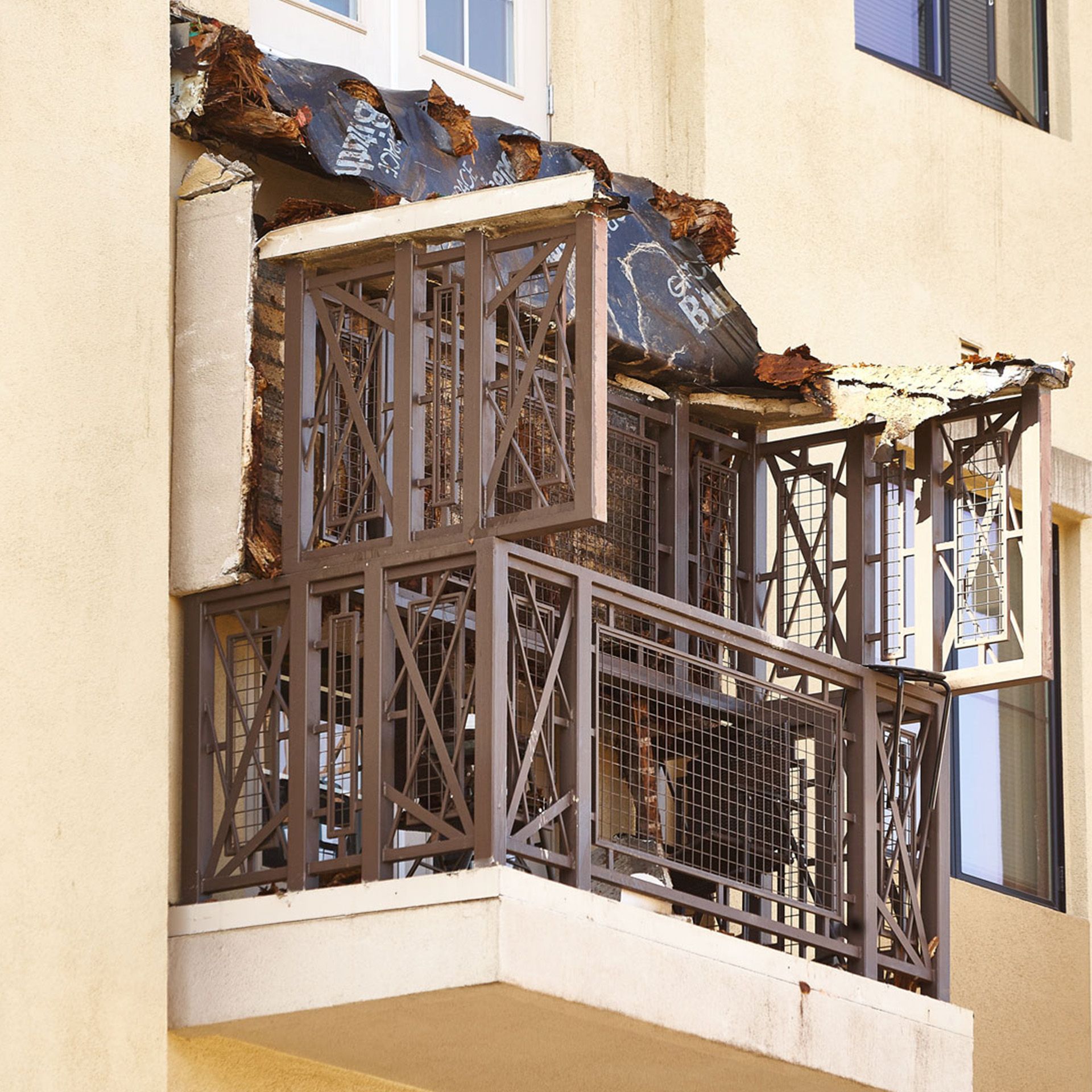 A balcony on a building with a roof that has been damaged