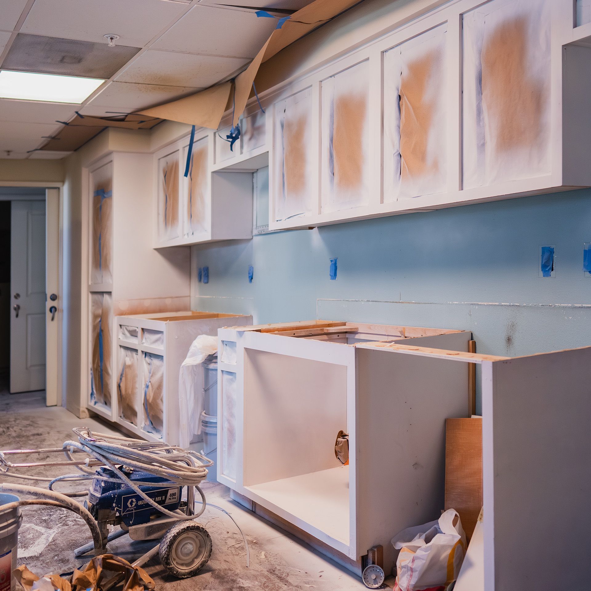 A kitchen that is being remodeled with white cabinets