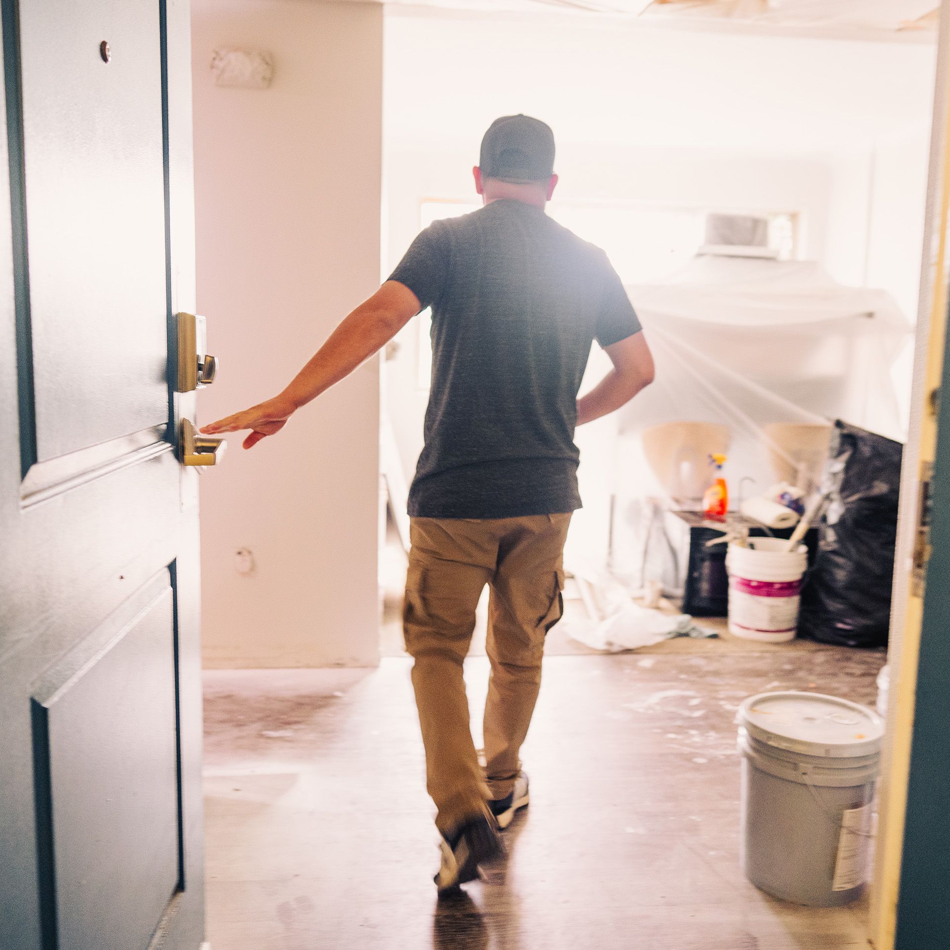 A man in a black shirt is walking through a doorway