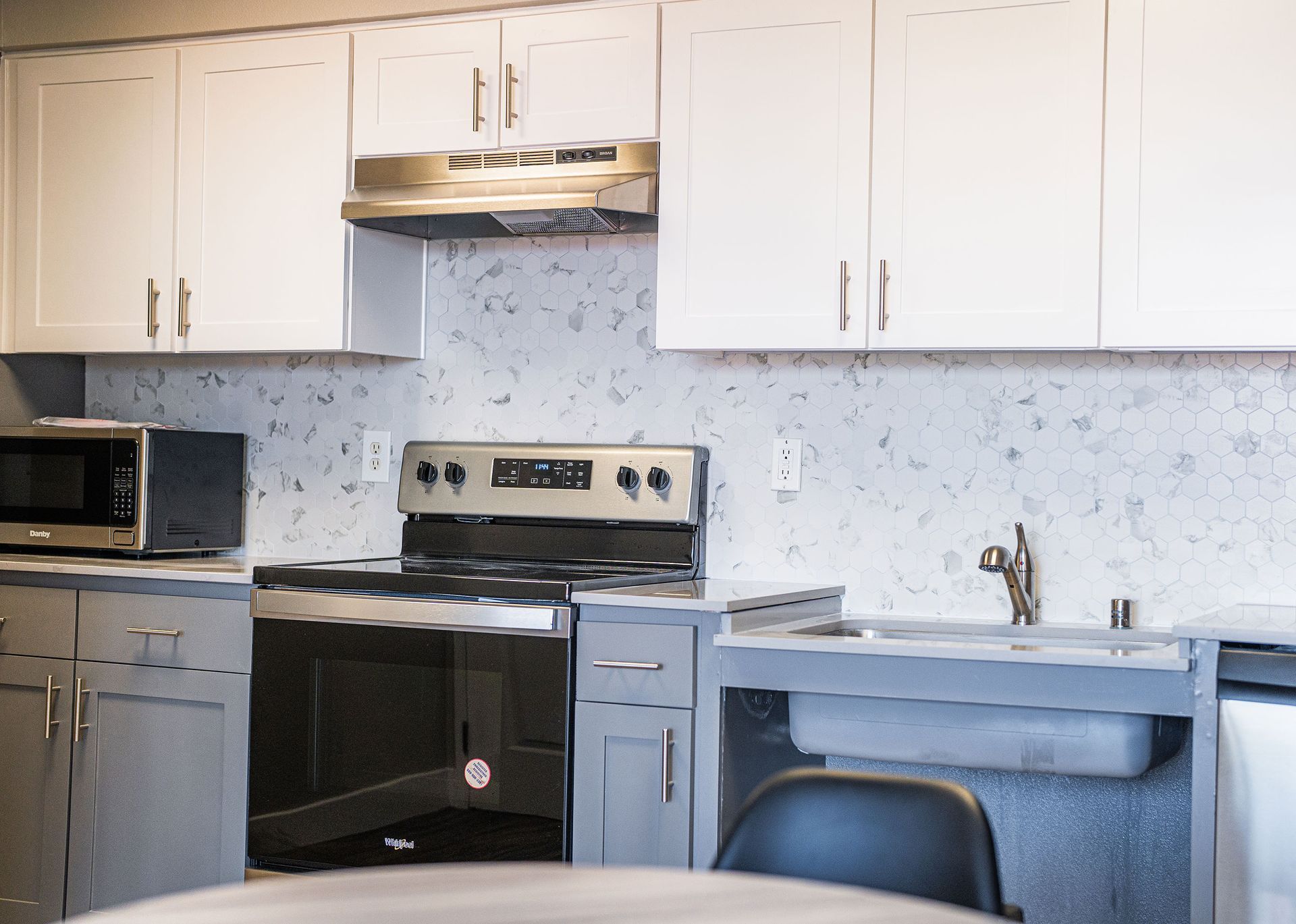 A kitchen with a stove a sink and a microwave