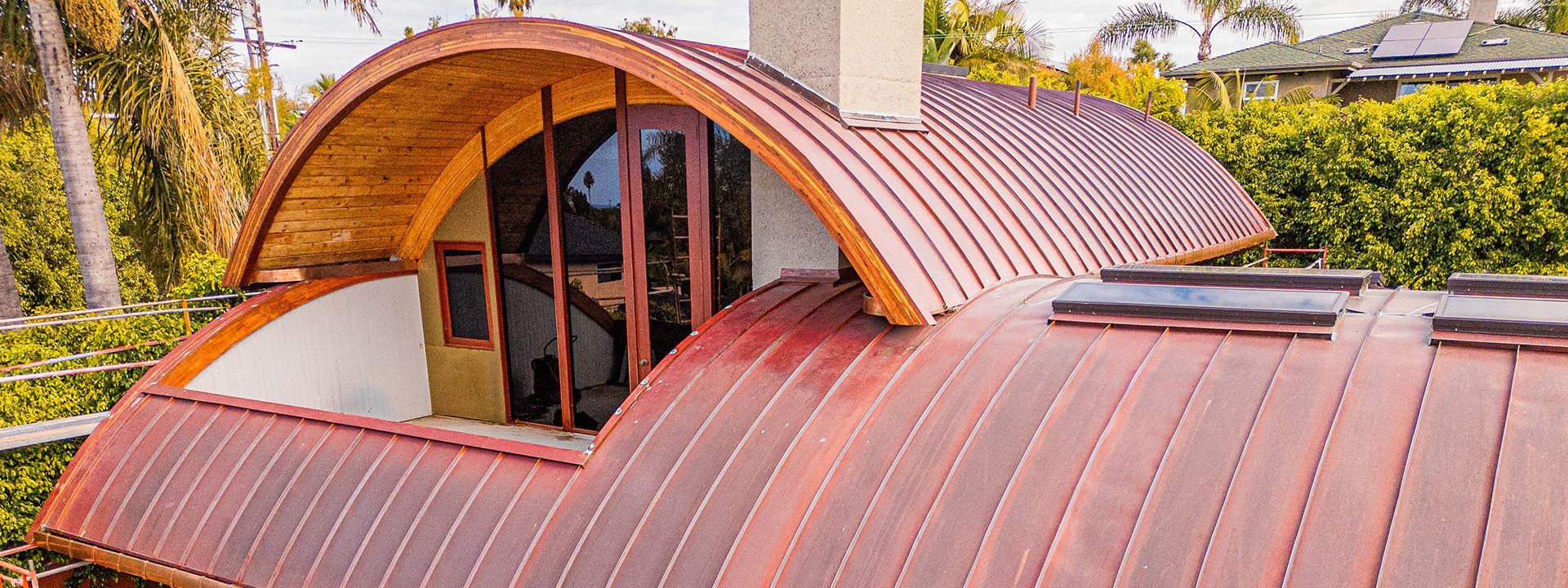A house with a curved roof and a large window.