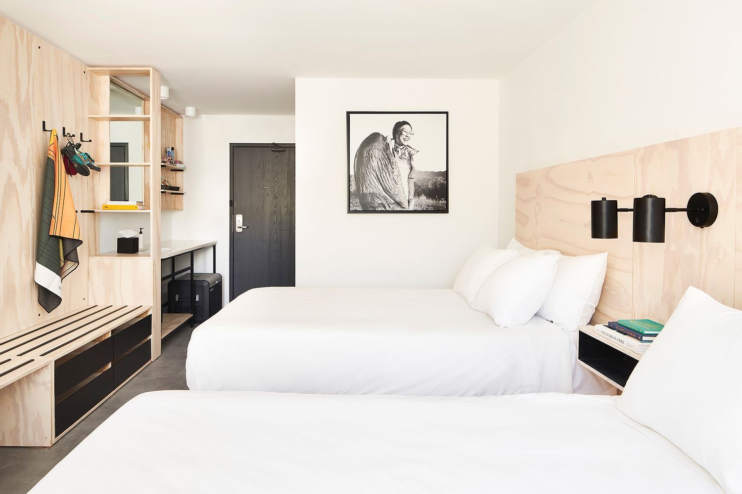 A hotel room with two beds and a picture on the wall.