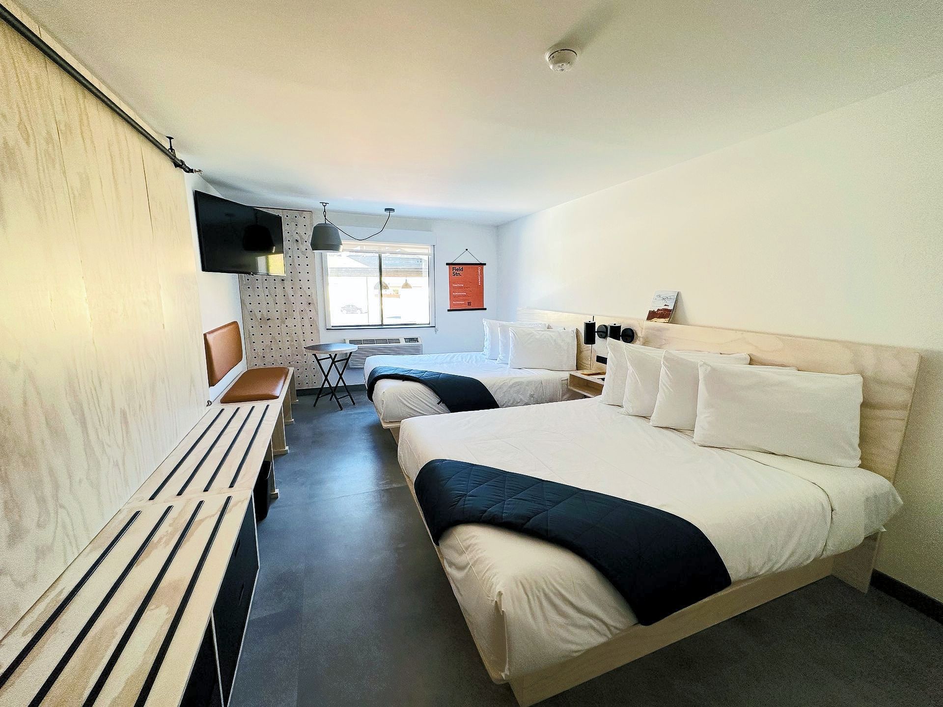 A hotel room with two beds and a desk.