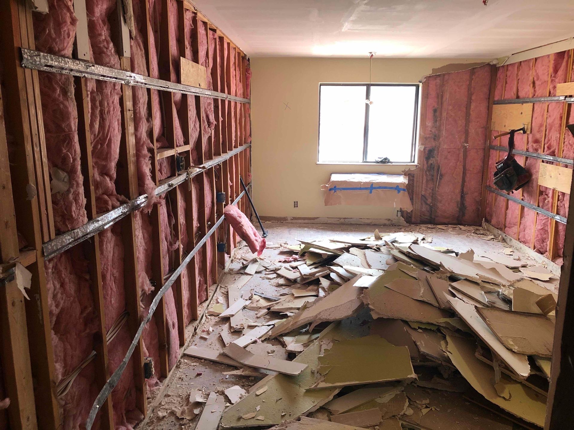 A room with a lot of junk in it and a window.