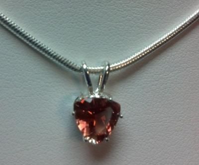 Heart-shaped reddish-brown gemstone pendant on a silver snake chain necklace.
