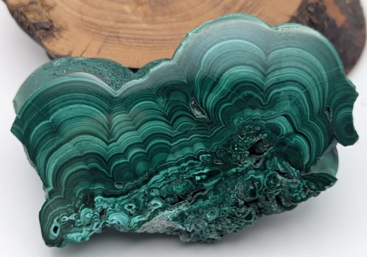 Green malachite stone with swirling, banded patterns.