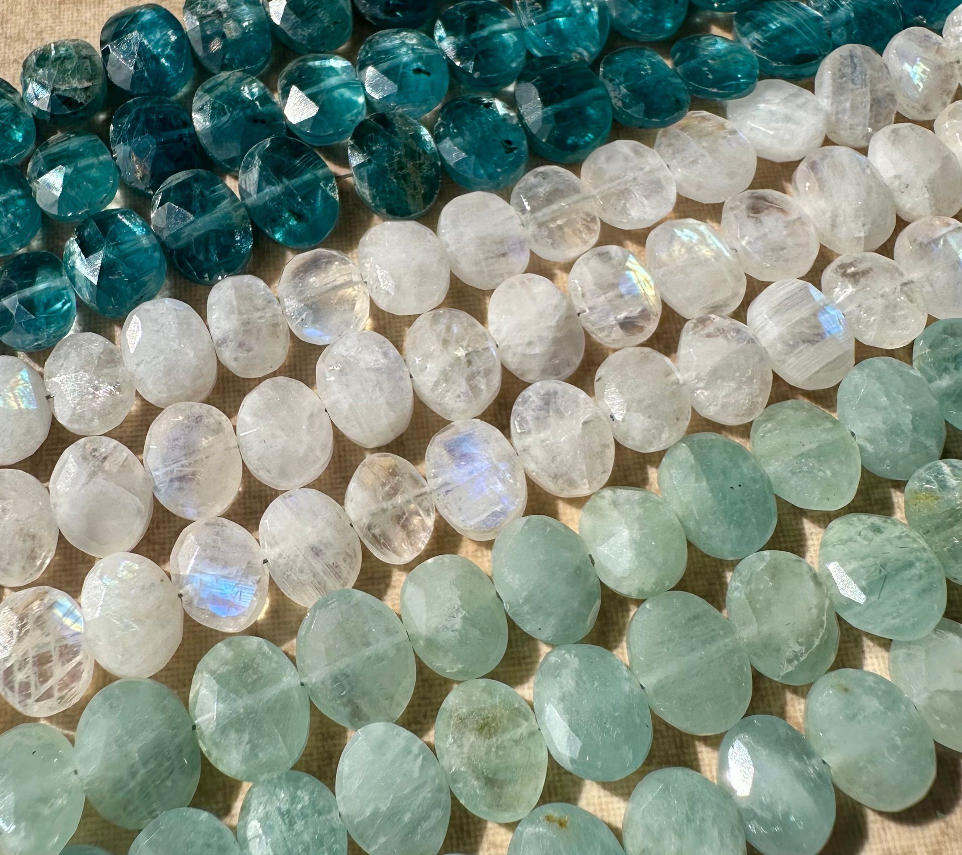 Rows of faceted gemstone beads in shades of teal, white, and aqua.
