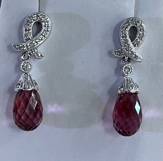 Pair of silver earrings with pink teardrop gems and diamond accents.