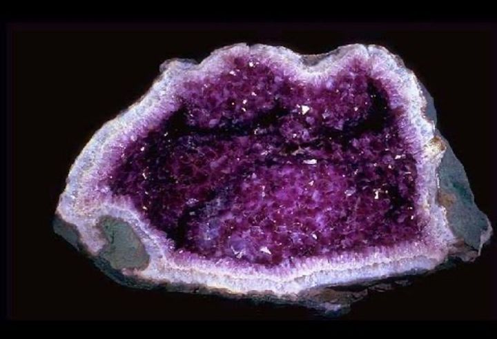 Amethyst geode, cavity lined with sparkling purple crystals. Gray and white outer rock.