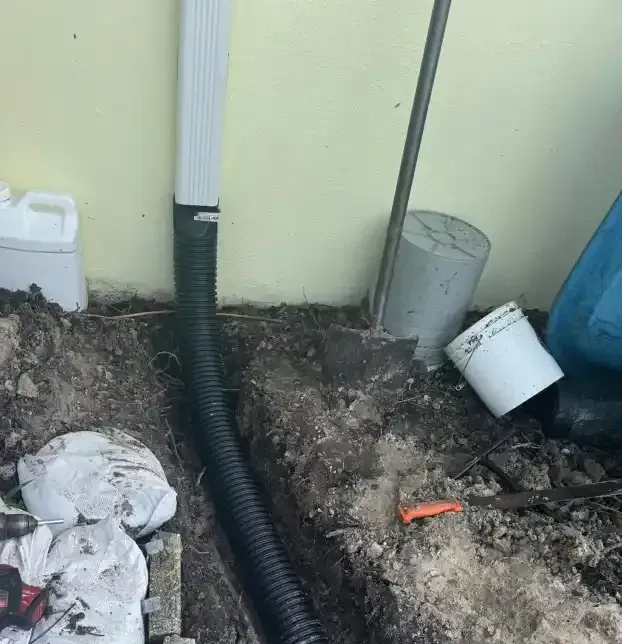 Downspout drainage pipe directing roof water away from a building in Fort Myers, FL