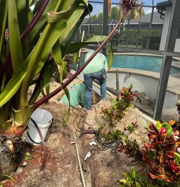 Sump pump discharge system directing collected water away from a landscaped area in Fort Myers, FL
