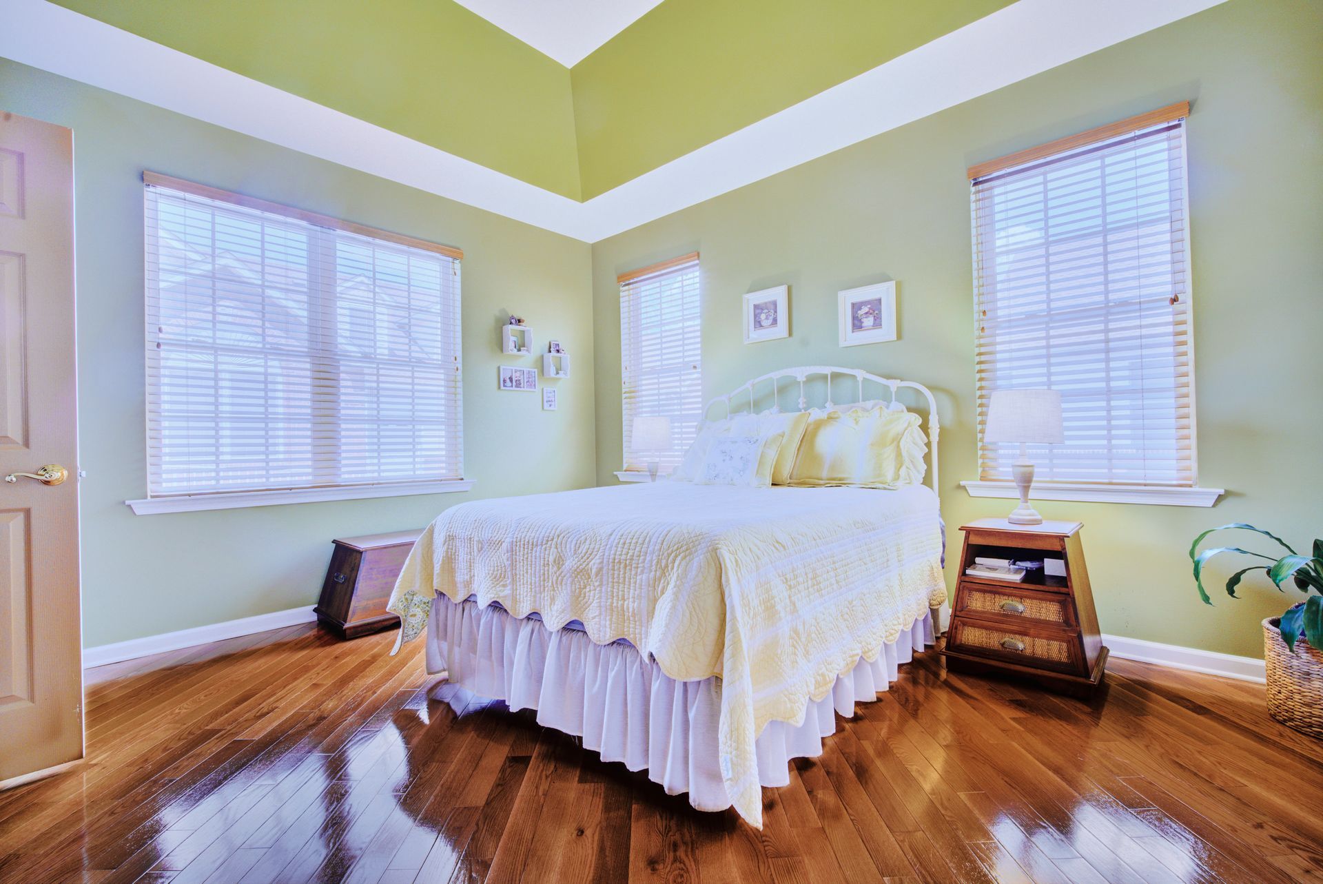 A bedroom with a bed , nightstand , and green walls.