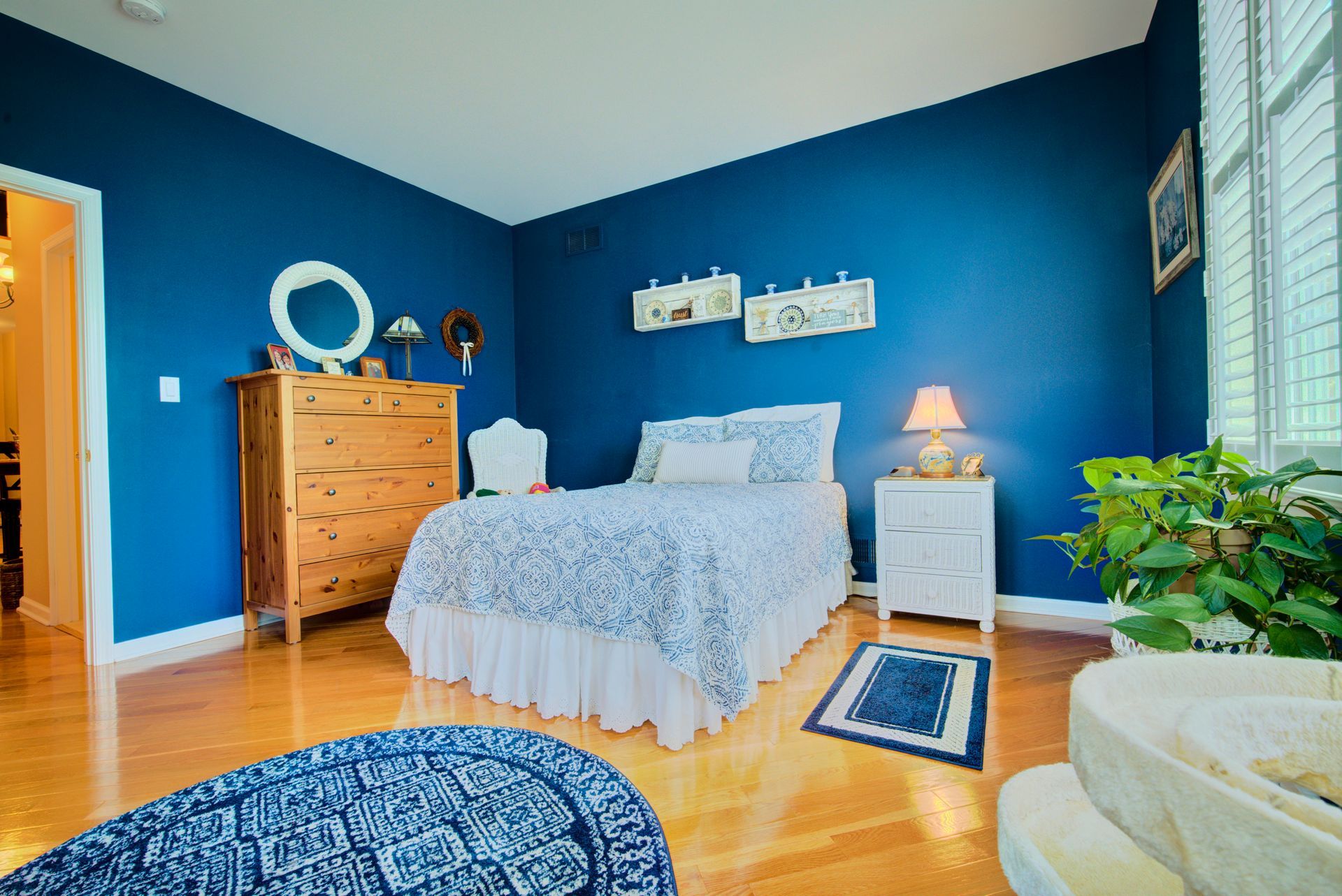 A bedroom with blue walls and a white bed