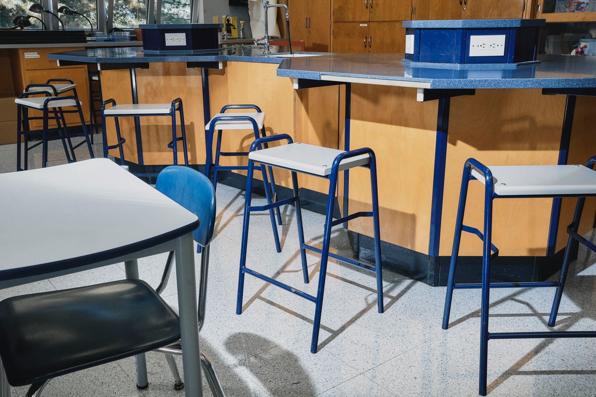 A row of tables and chairs in an empty classroom