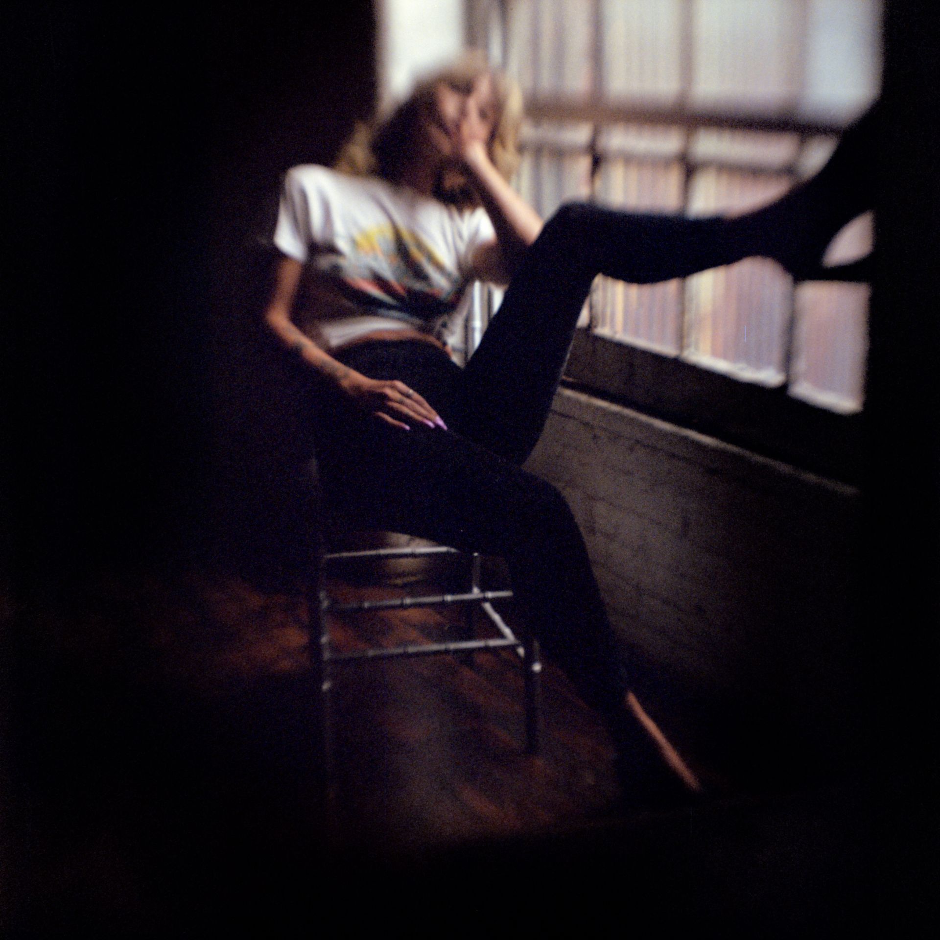 Silhouetted person standing before a bright window in a dark, smoky room
