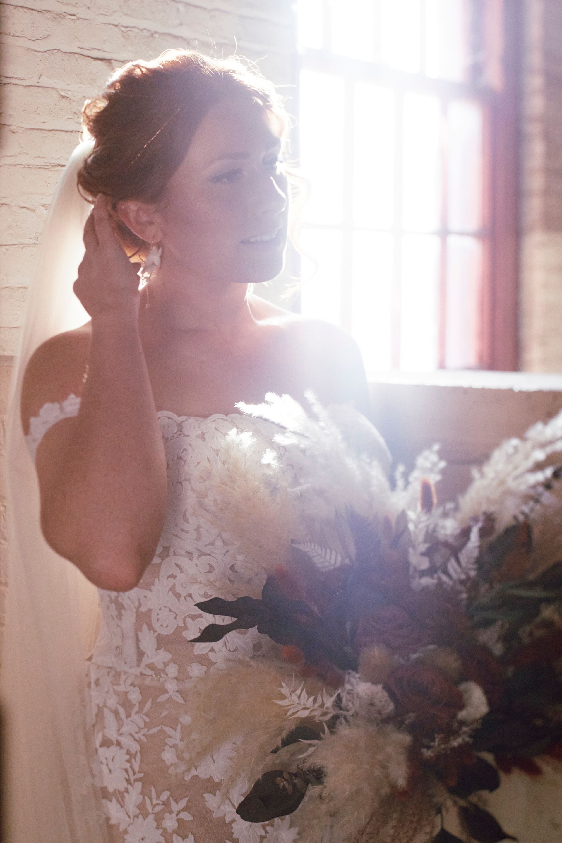 The bride is wearing a veil and holding a bouquet of flowers.