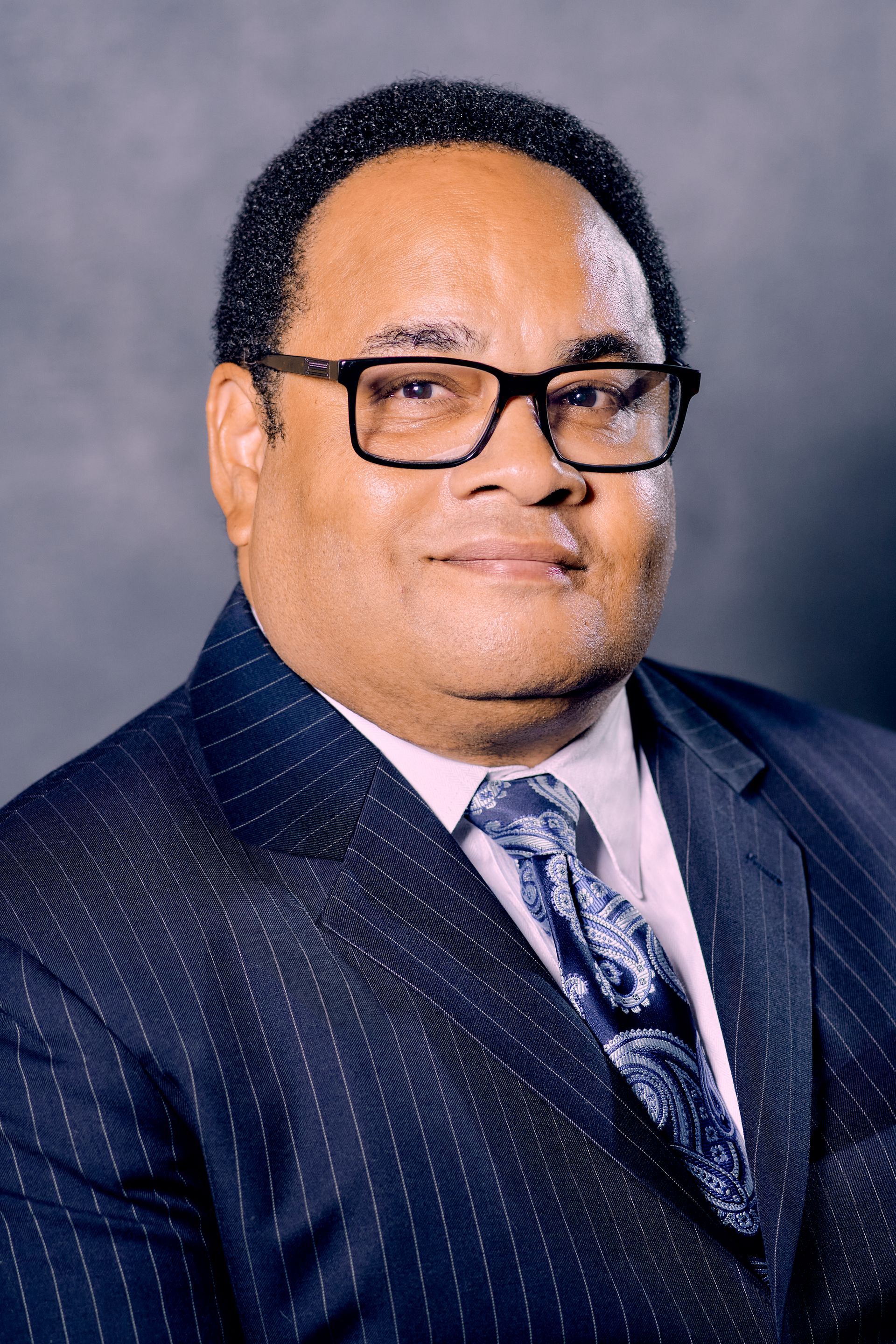 A man in a suit and tie is wearing glasses.
