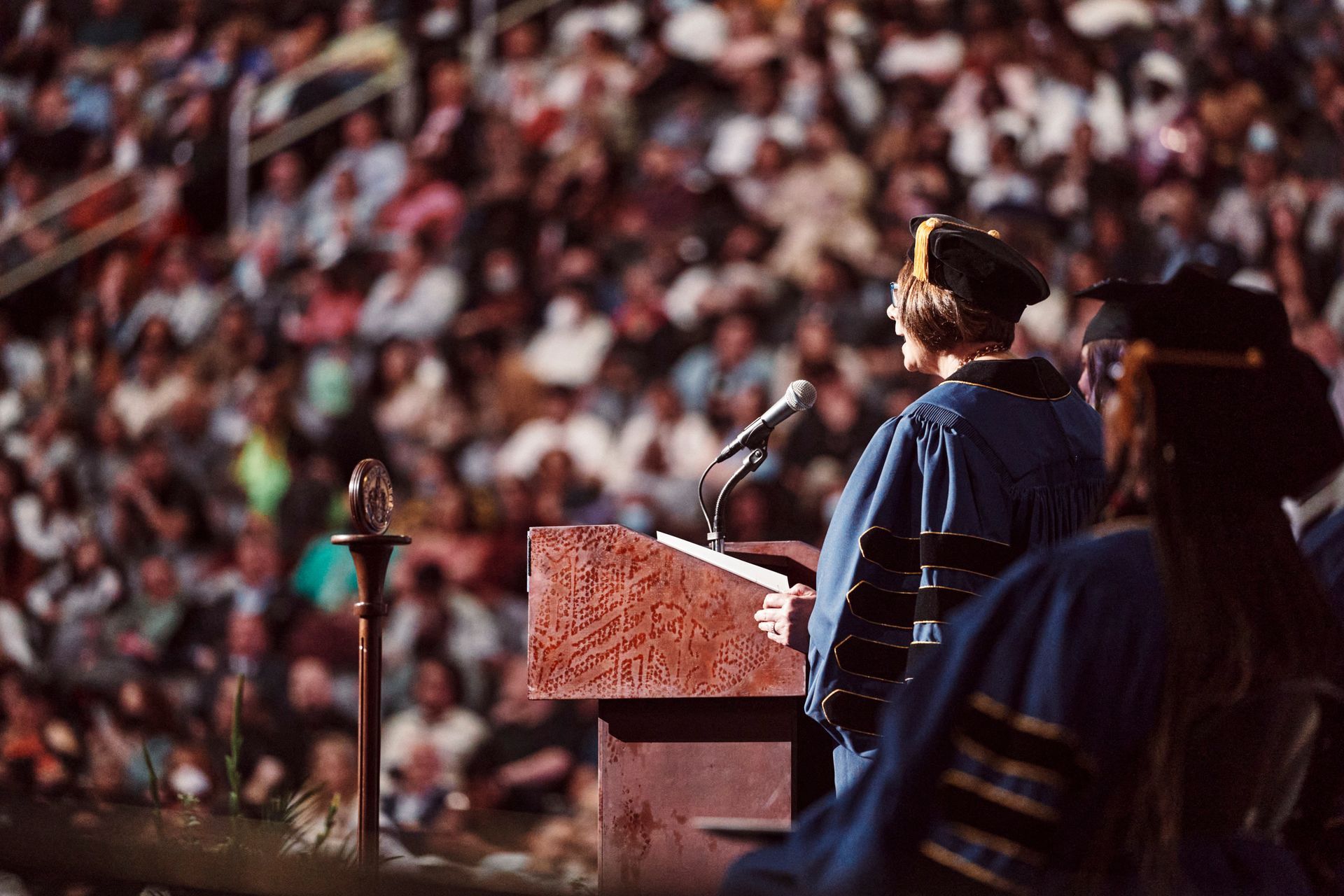A woman is standing at a podium giving a speech in front of a crowd.