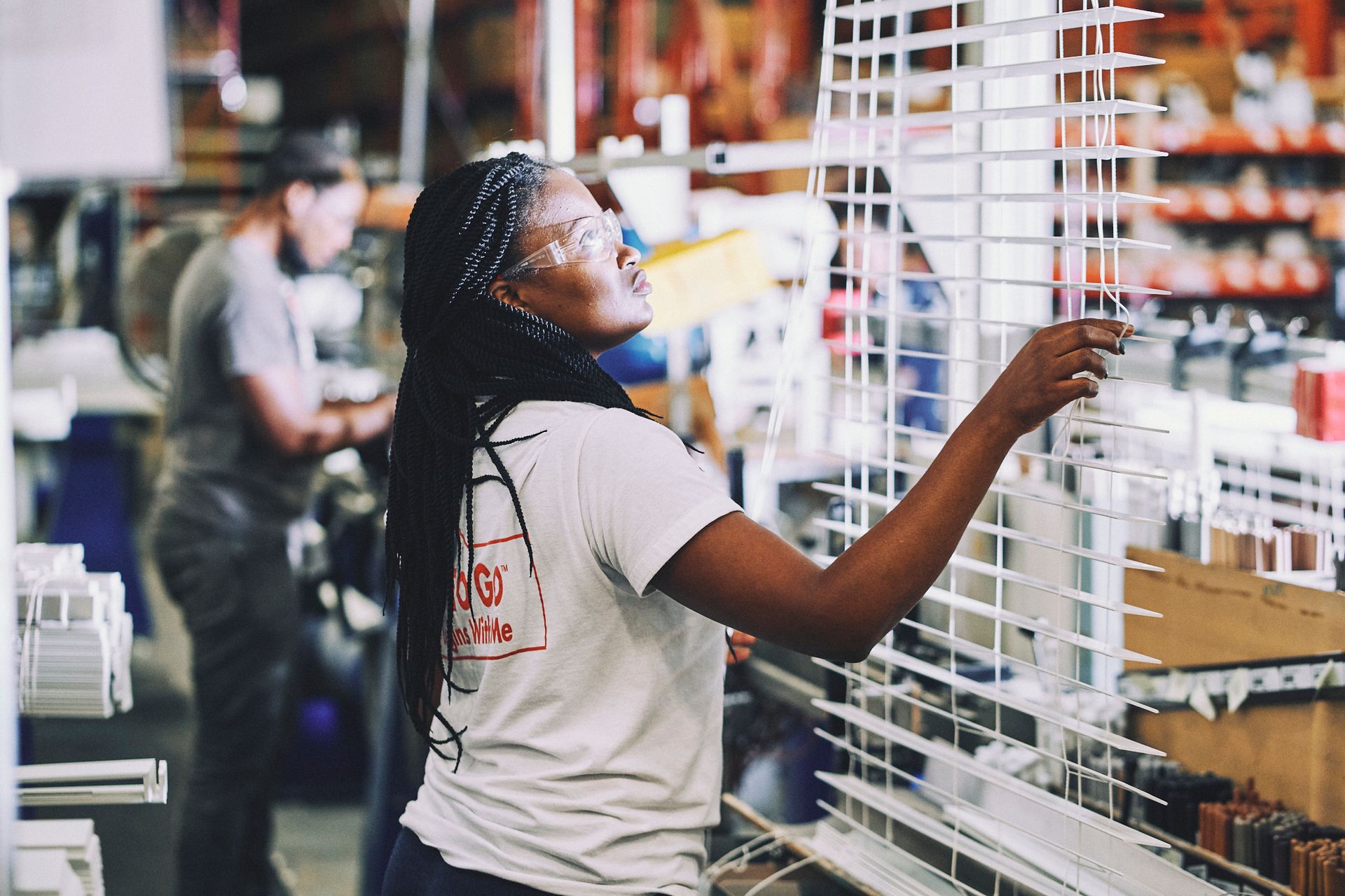 A woman in a white shirt is working in a factory.