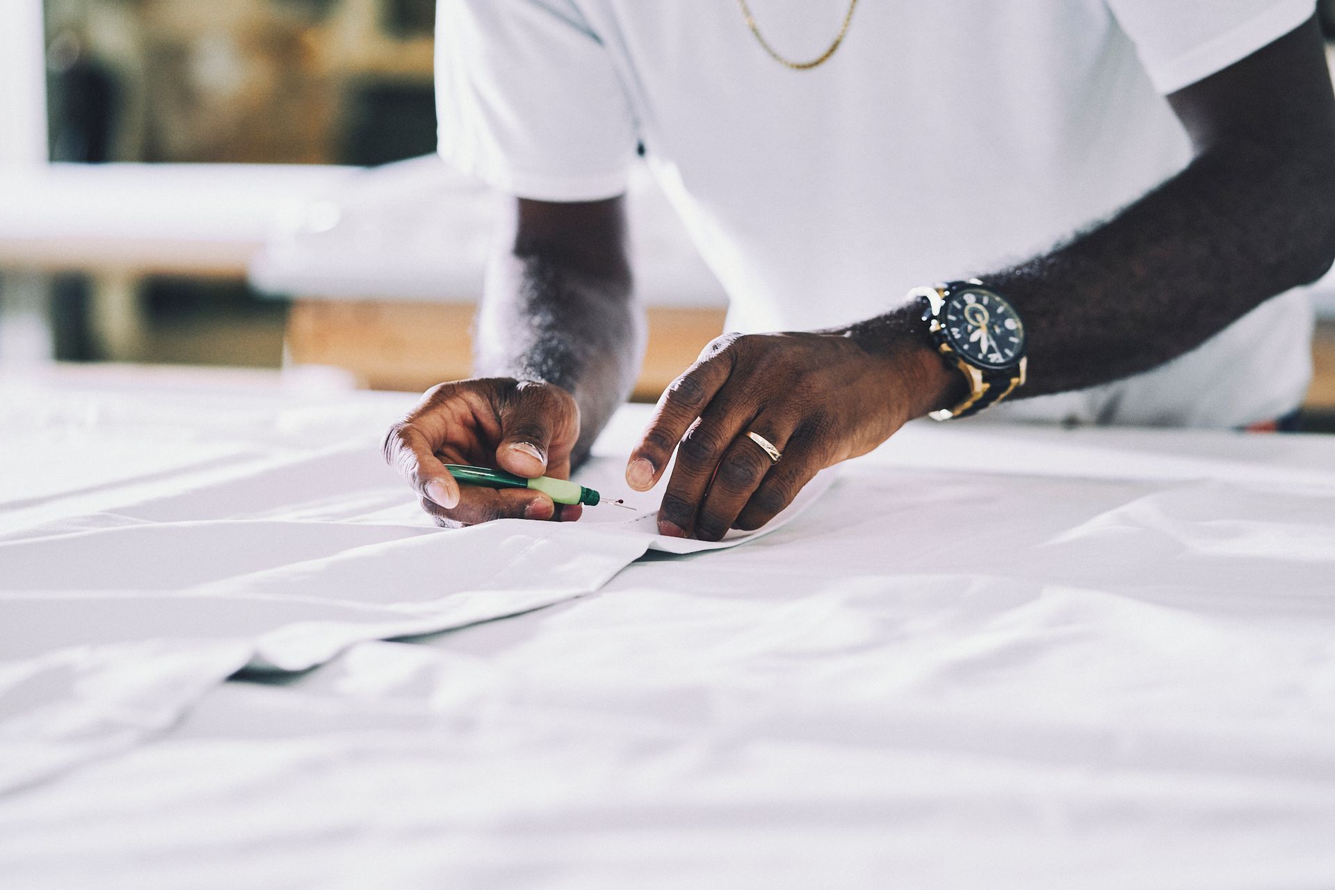 A man is drawing on a piece of paper with a marker.