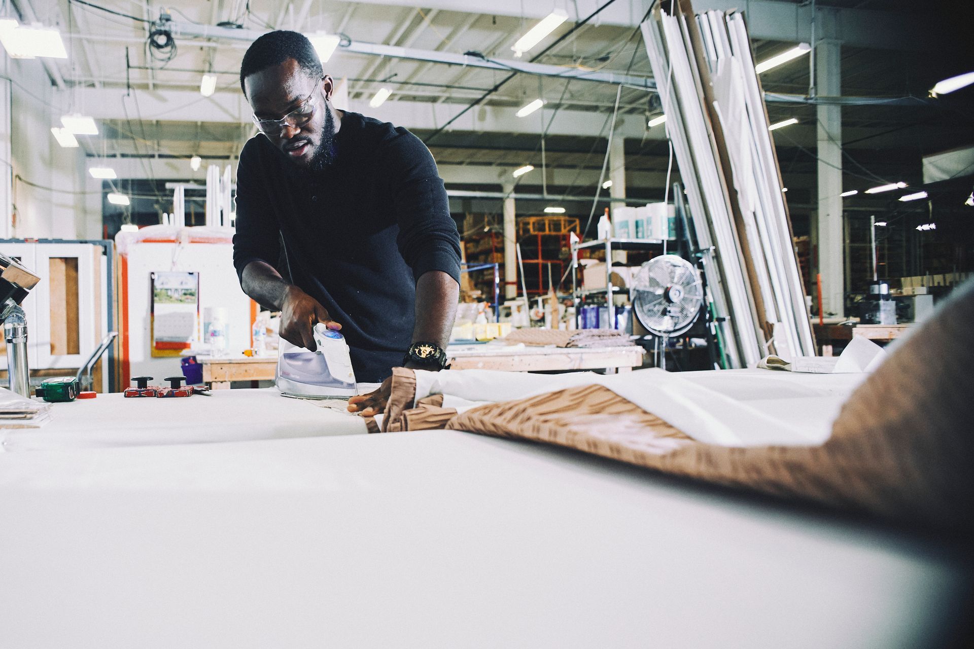 A man is working on a piece of wood in a factory.