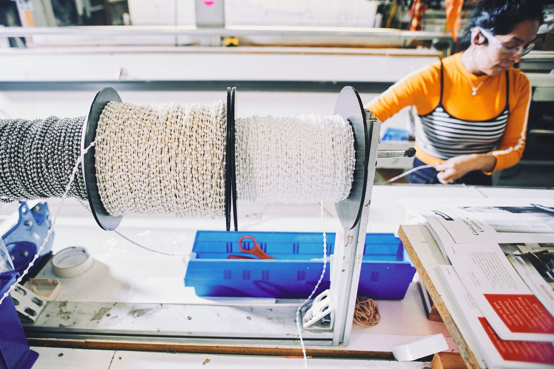 A woman wearing headphones is working on a machine in a factory.