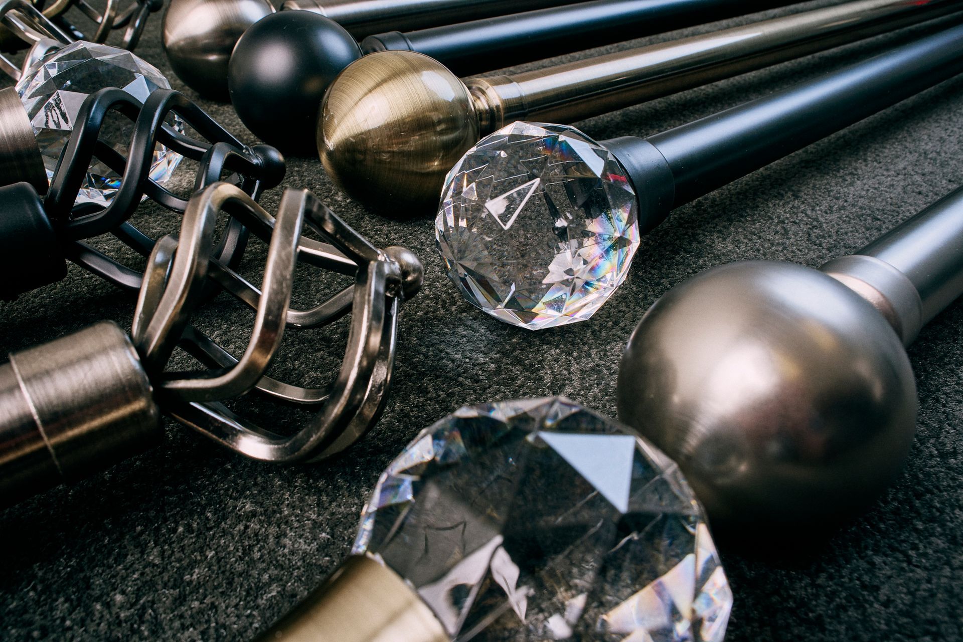 A bunch of different types of curtain poles are sitting on a table.
