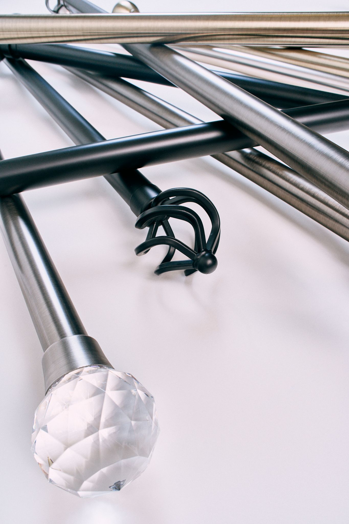 A bunch of metal poles are stacked on top of each other on a white surface.