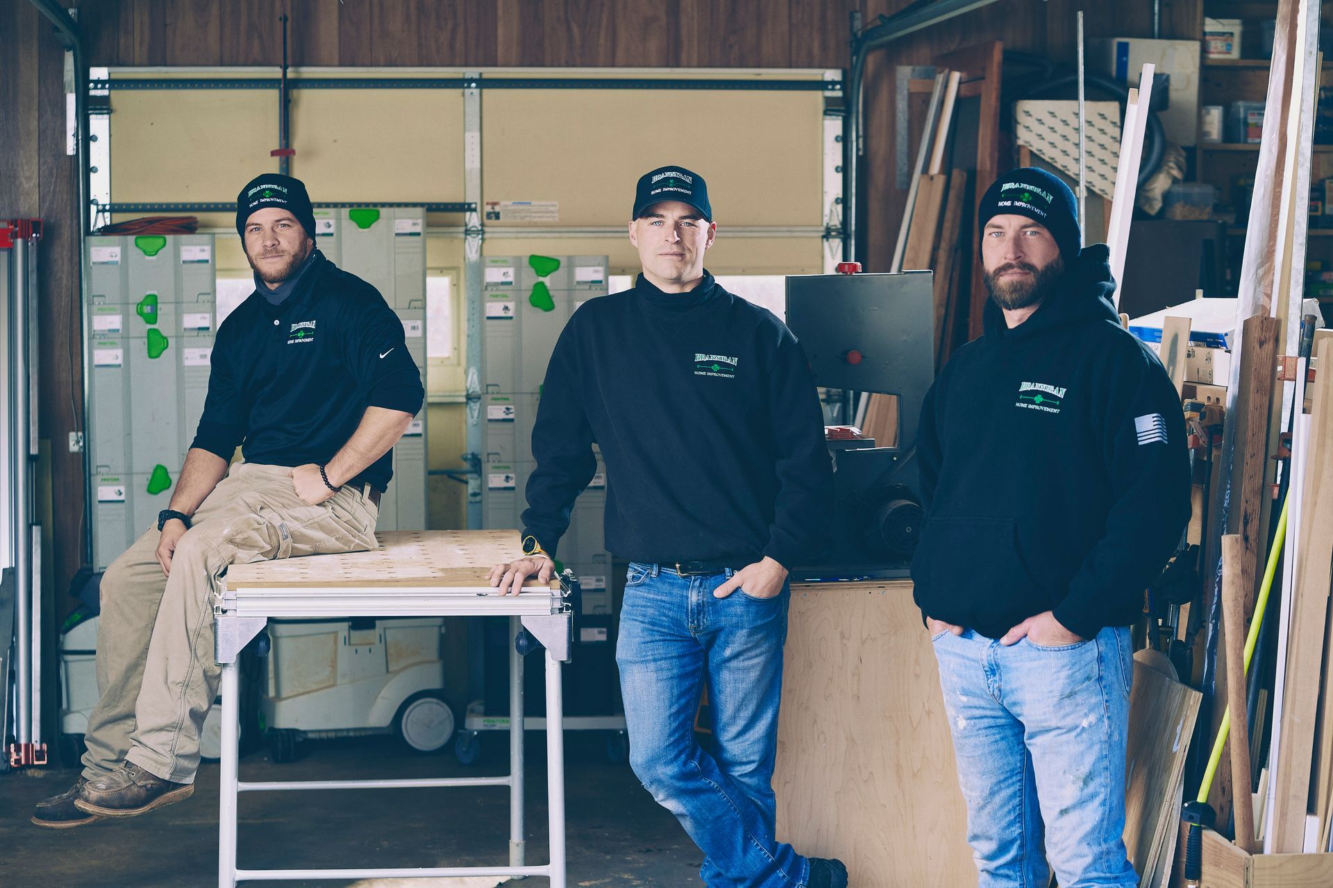 Three men are standing next to each other in a workshop.