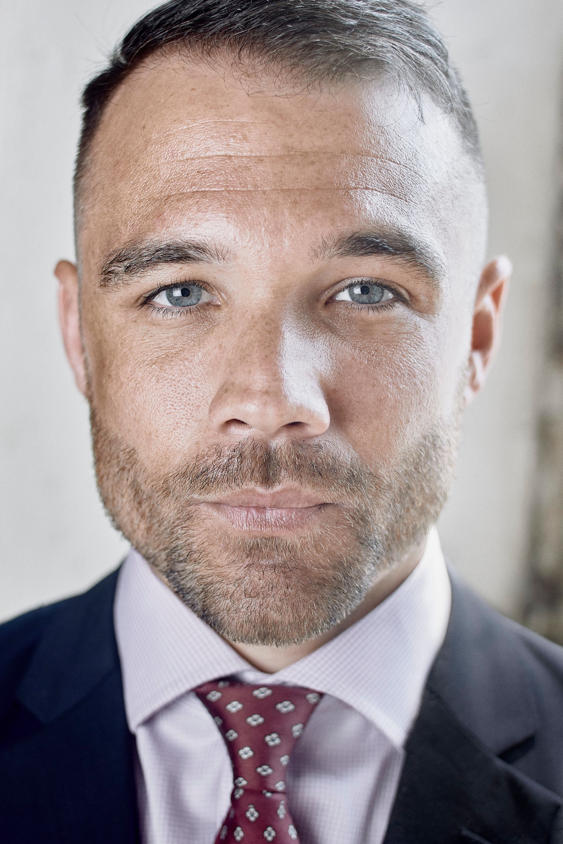 A man with a beard is wearing a suit and tie