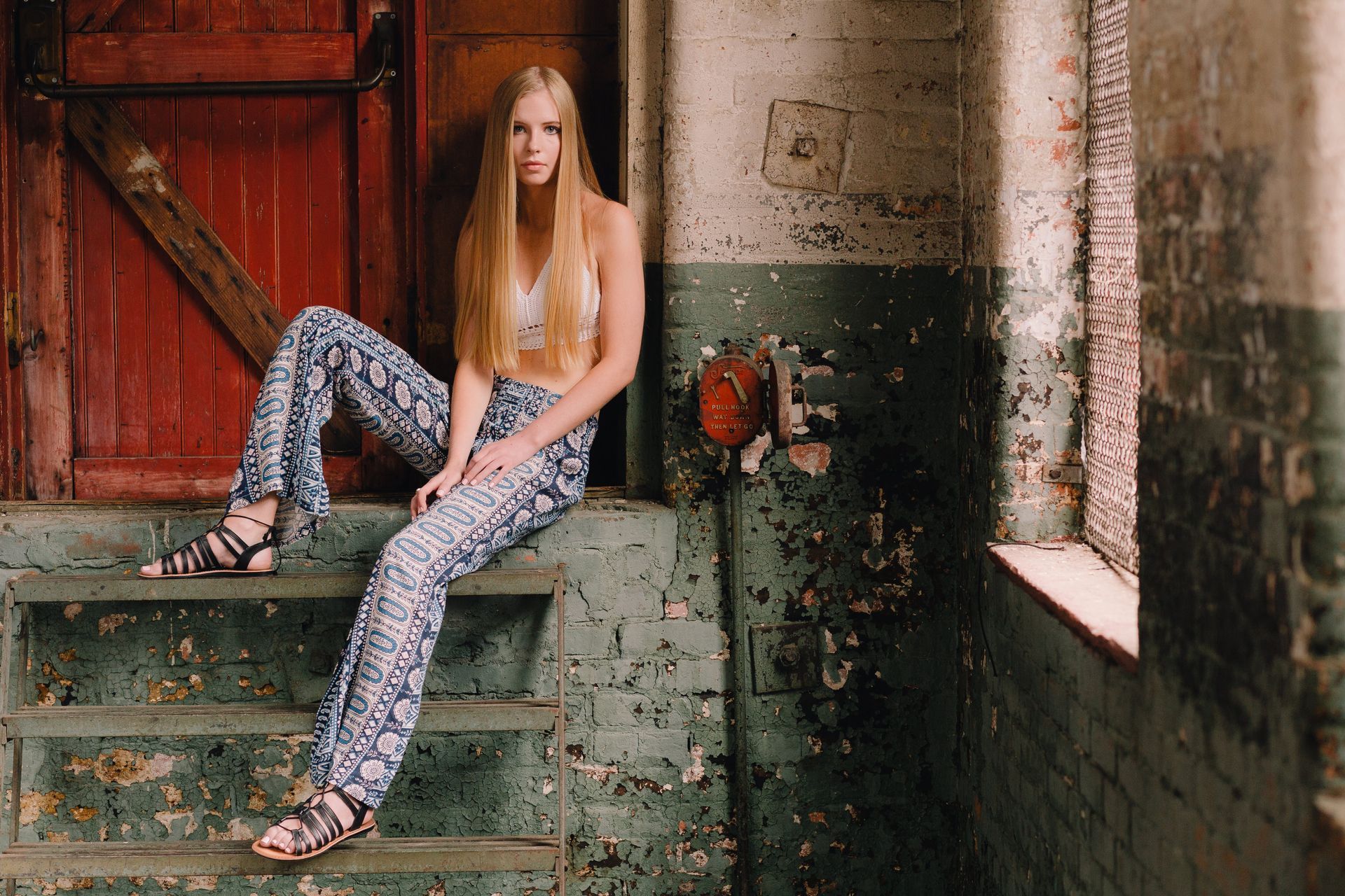 A woman is sitting on a set of stairs in a building.