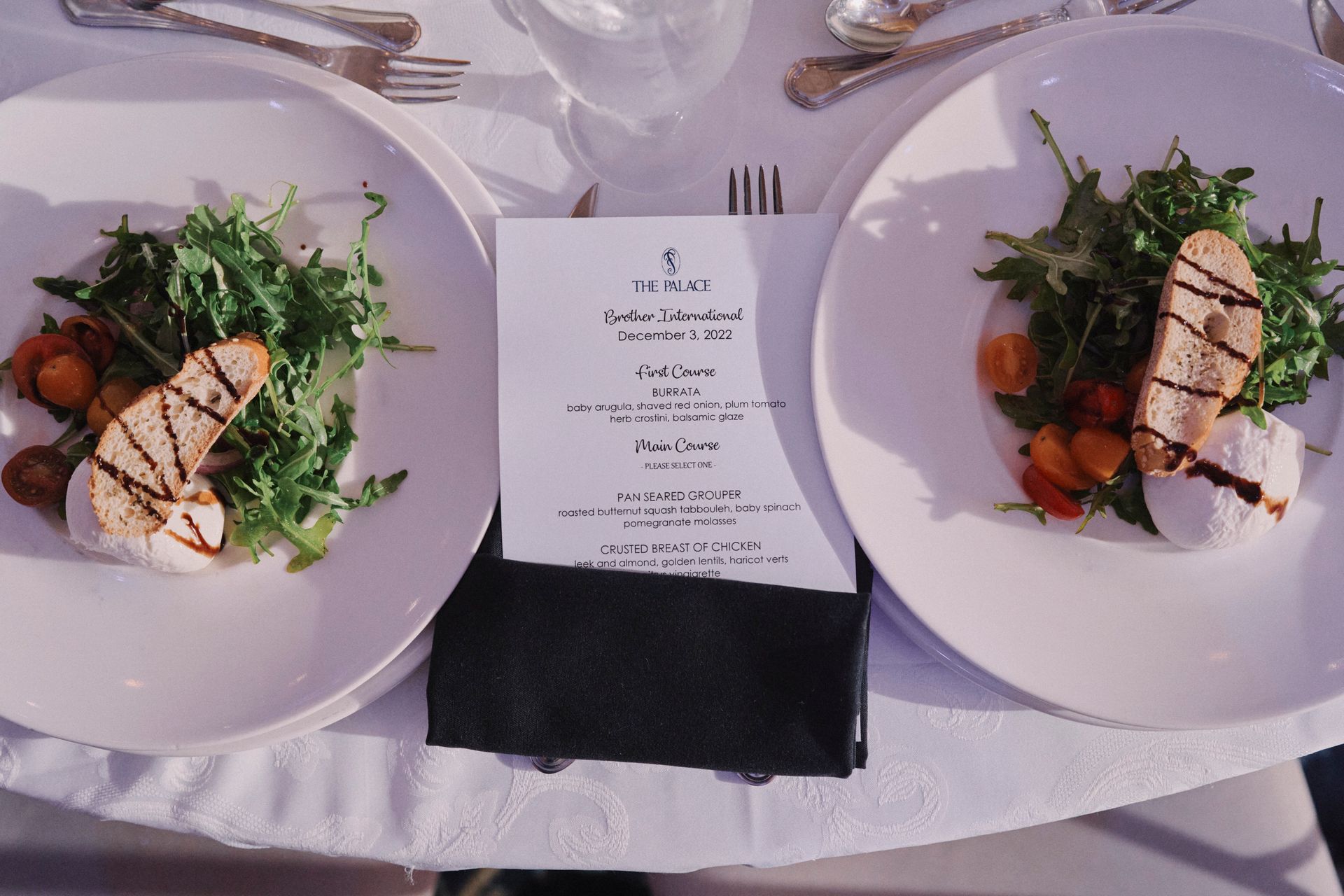 Two plates of food and a menu on a table.