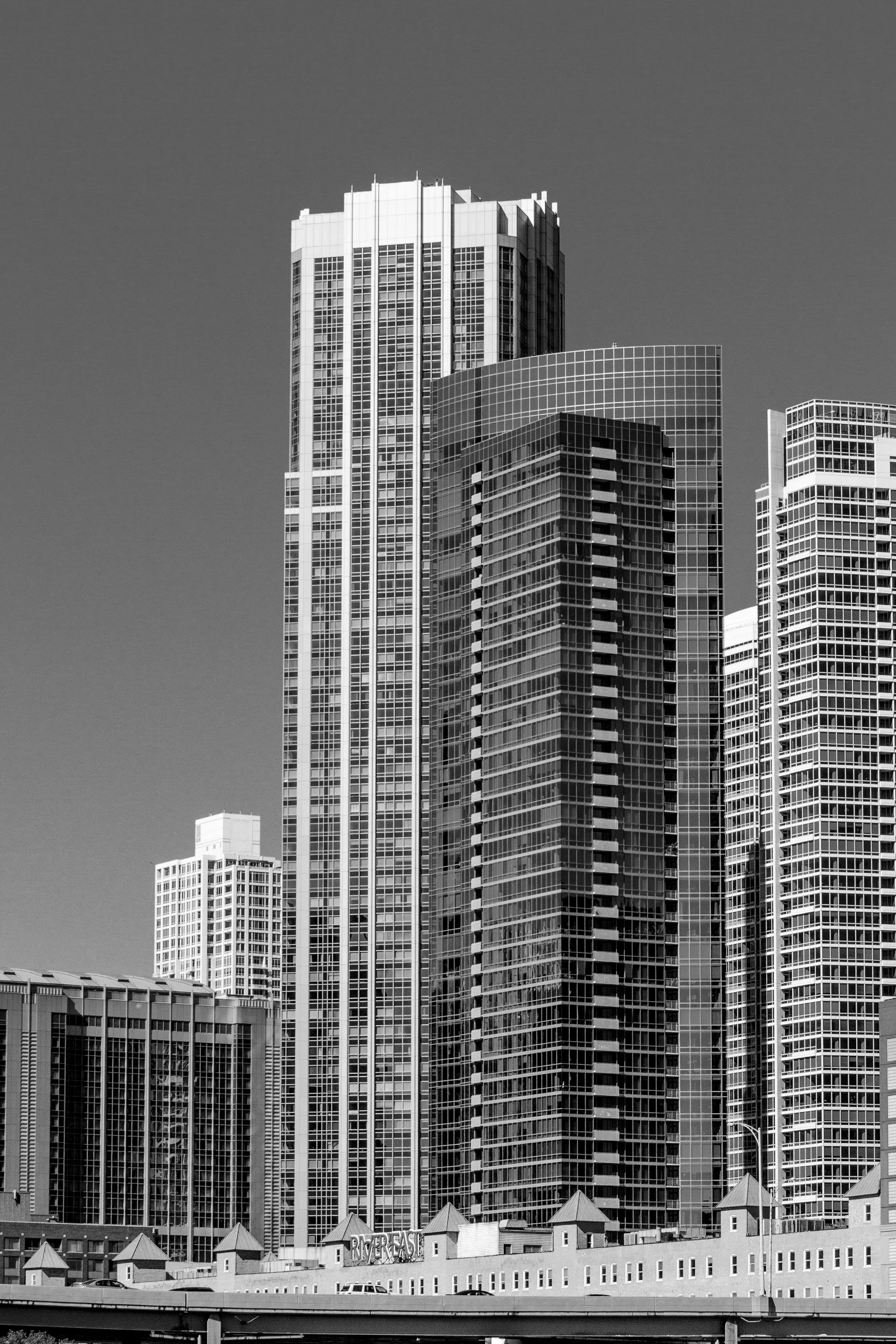 Black and white photo of tall buildings and skyscrapers against a clear sky.