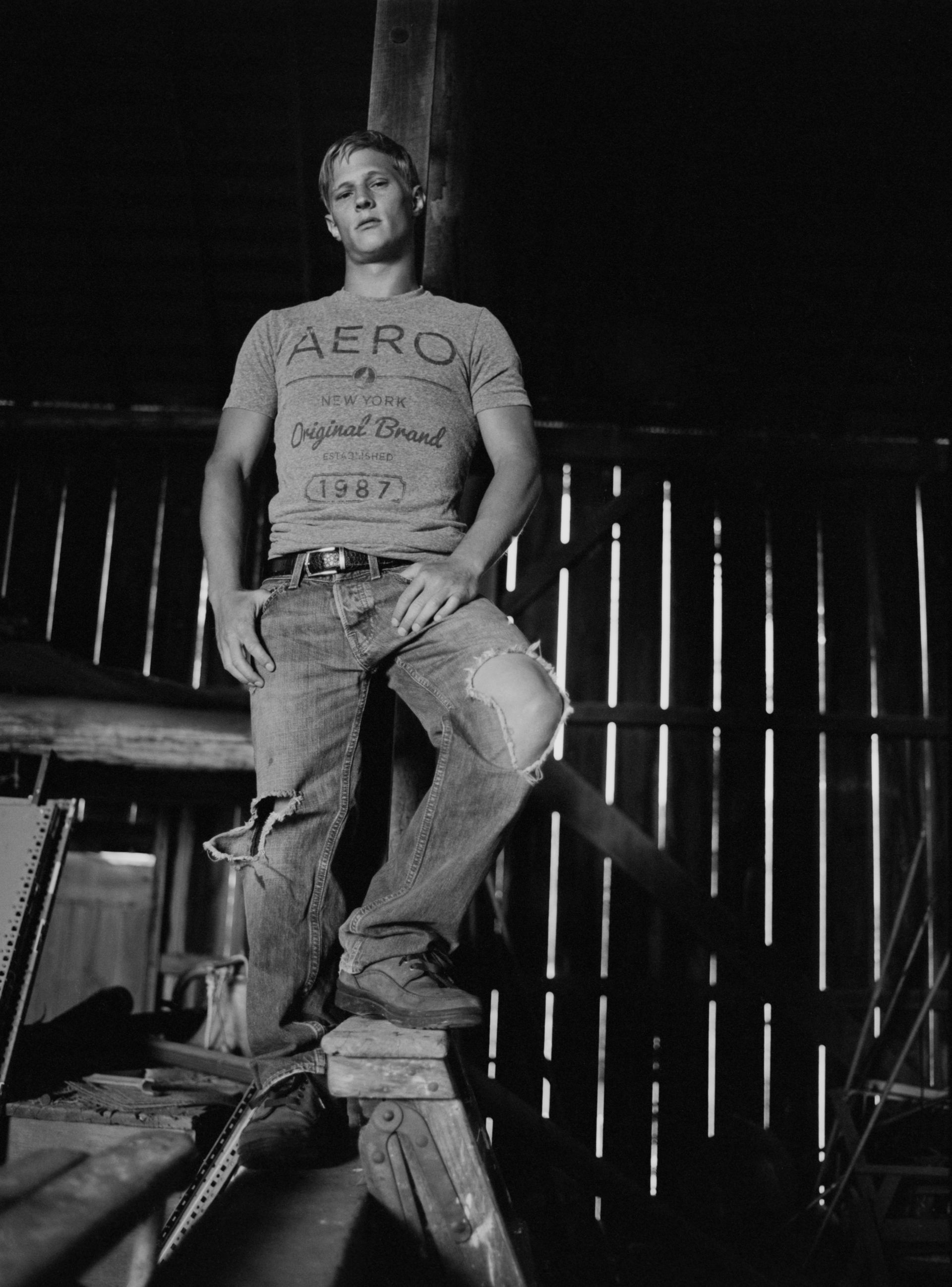 A black and white photo of a man wearing a aeropostale shirt